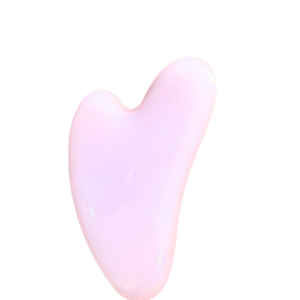Rose quartz gua sha facial massage tool used for skincare, relaxation, and emotional healing.